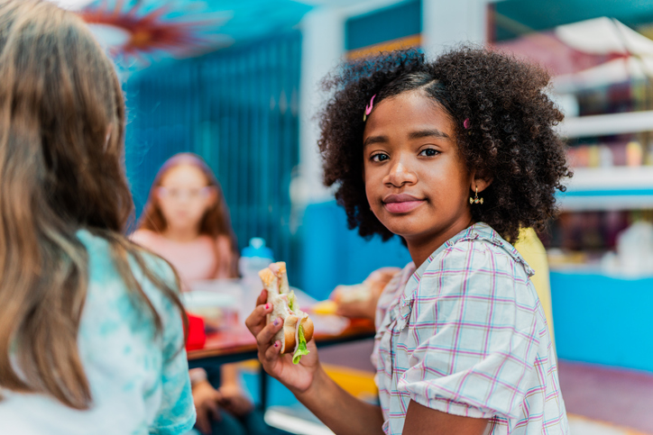 Portrait of child girl eating on snack time at school