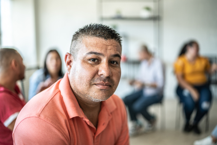 Portrait of mid adult man during a group therapy at mental health center