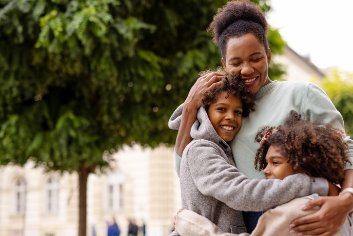 Black Family Single Mother, Son and Daughter Hugging and Smile in the City. Loving Mom, Boy and Girl