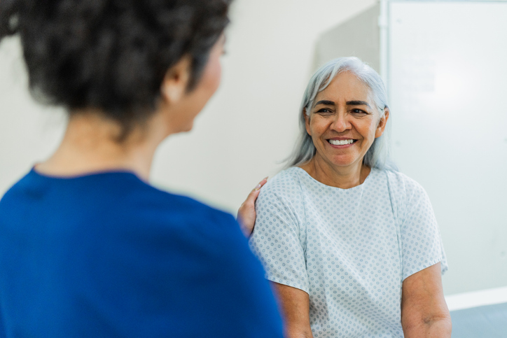 Senior patient woman talking to nurse at hospital
