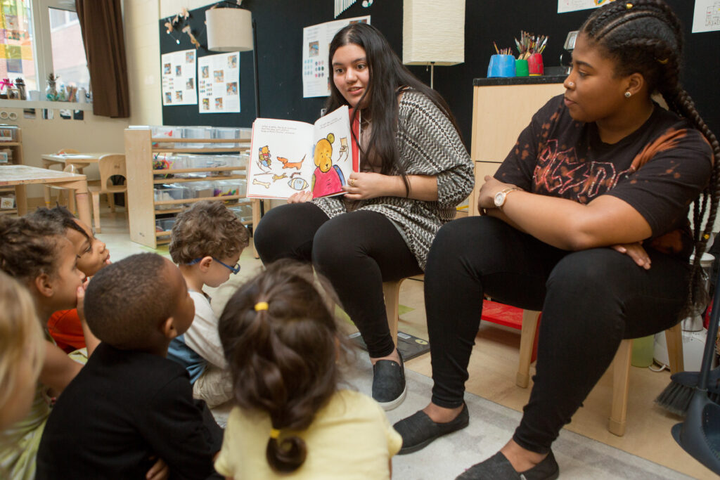 High school student teachers read a book to a preschool class.