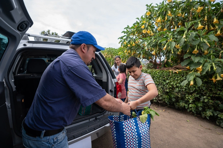 Latin American family arriving home and unloading shopping bags from the car