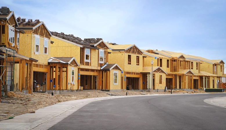 Single family homes under construction on an empty street